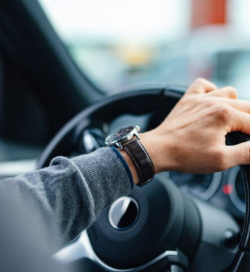 A close up view of an unrecognizable Caucasian male working as a taxi driver.